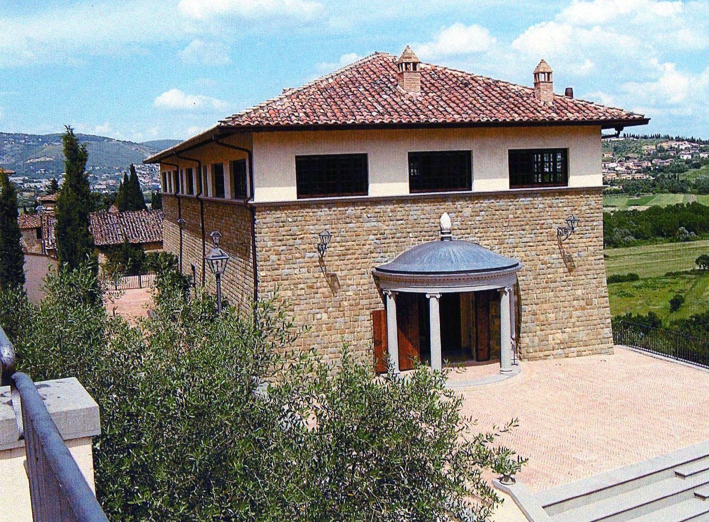 The stone exterior of the Cucinelli Theatre in Solomeo, with its columned entrance porch.