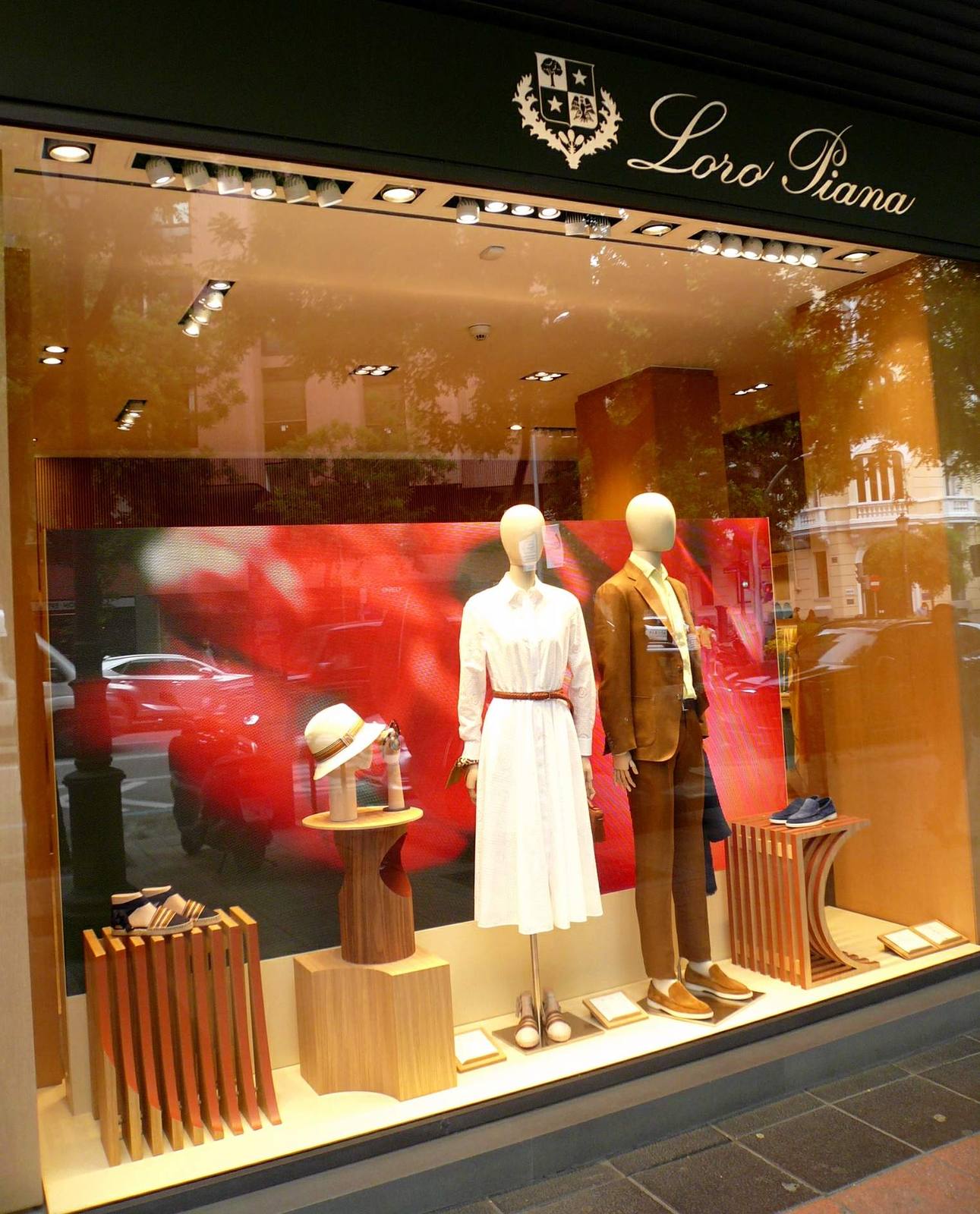 The window of the Loro Piana boutique in Madrid, showing mannequins, clothing and loafers.