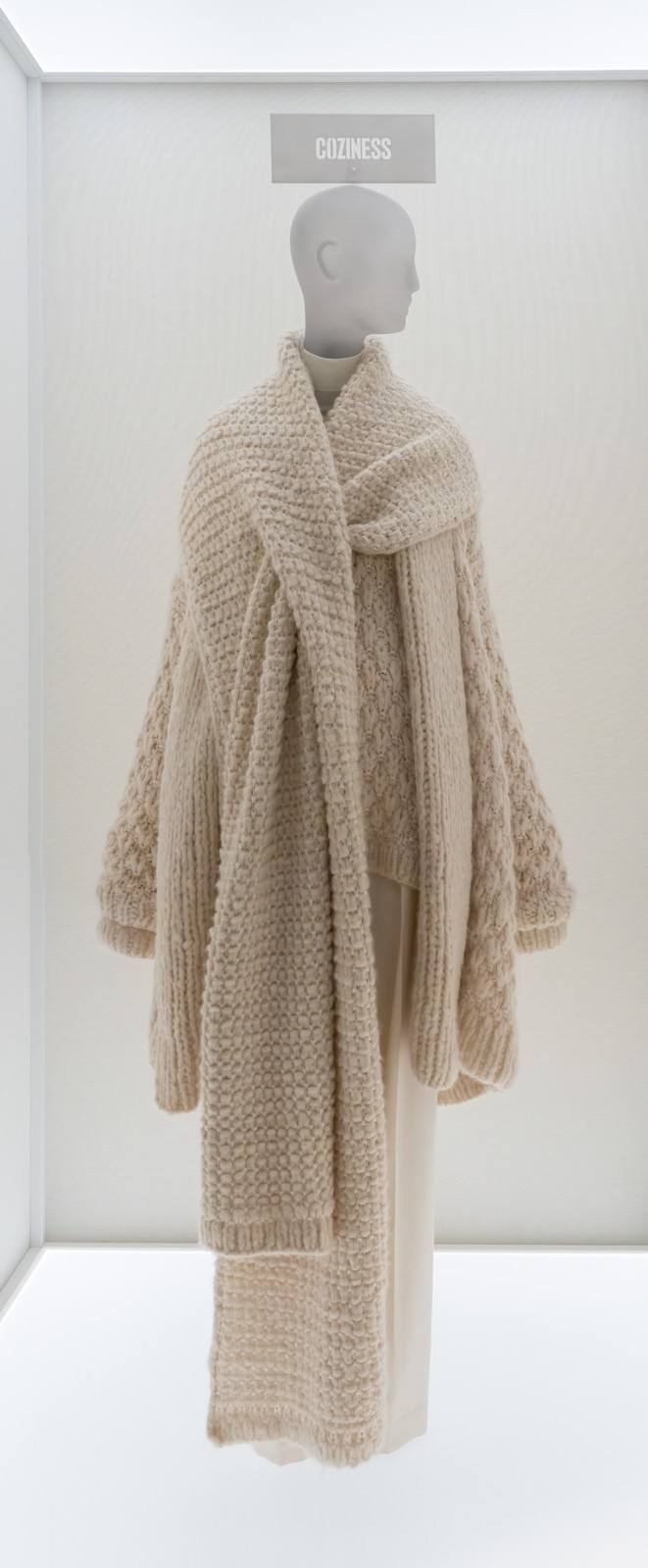 A cream knitted sweater and long scarf by The Row on a mannequin at the Metropolitan Museum of Art.